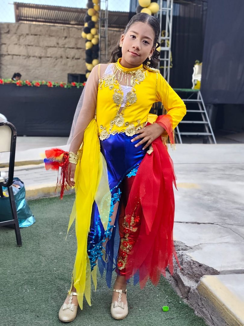 Solangela posando con su traje amarillo, azul y rojo